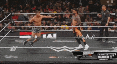 two men in a wrestling ring with a sign that says " tomorrow "