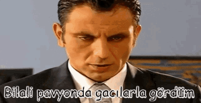 a man in a suit and tie is making a funny face with a caption .