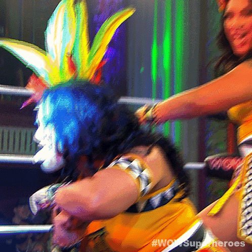 a blurred image of two women in a wrestling ring with #wowsuperheroes on the bottom