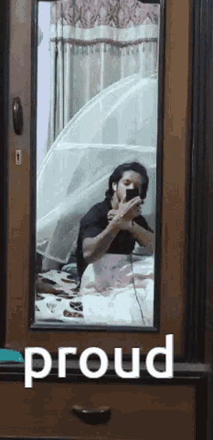 a person is taking a picture of themselves in a mirror with the word proud below them