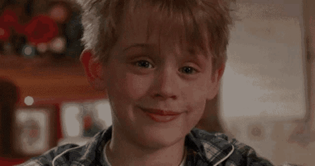 a close up of a young boy 's face smiling .