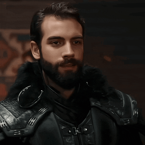 a man with a beard wearing a black jacket