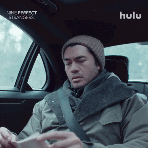 a man sitting in a car with hulu written on the bottom