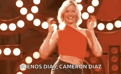 a woman in a red top is dancing on a stage with the words buenos dias cameron diaz .