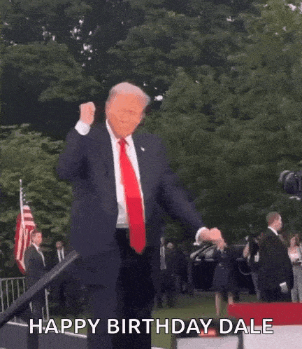 a man in a suit and tie is dancing in front of a crowd and says `` happy birthday dale '' .