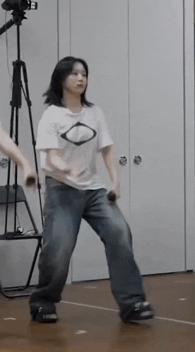a woman is dancing in a room with a microphone in her hand .