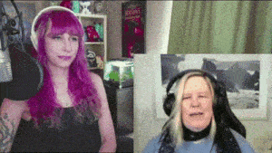 a woman with purple hair is talking into a microphone next to another woman wearing headphones .