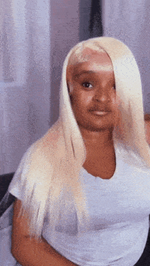 a woman with long blonde hair is wearing a white shirt and a nose ring .