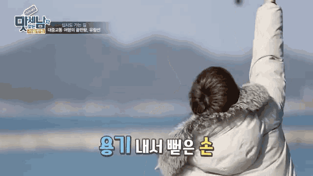 a person with their arms in the air with korean writing on the bottom of the screen