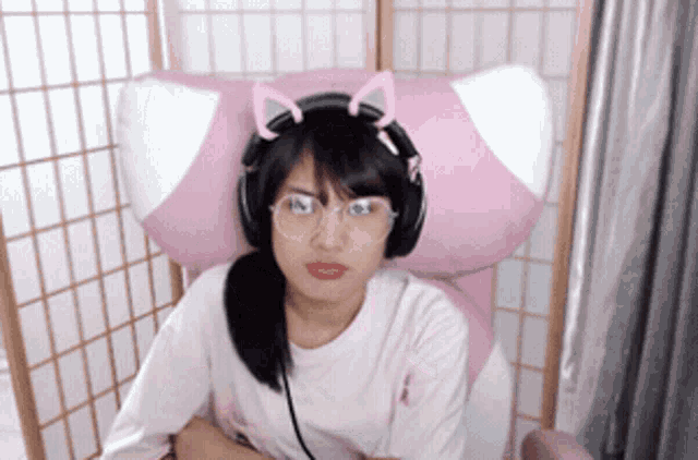 a girl wearing headphones and cat ears is sitting in a chair