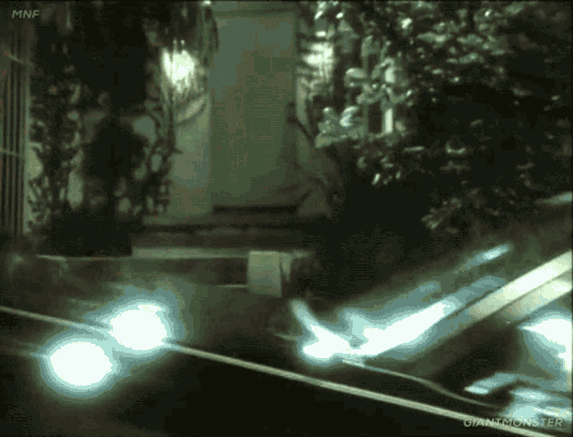 a car is parked in front of a house with giantmonster written on the bottom of the screen