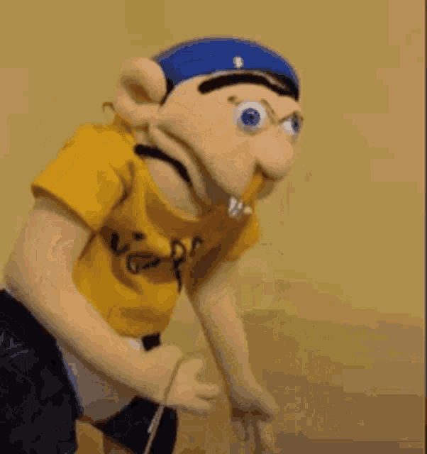 a puppet is holding a rope in its mouth while wearing a yellow shirt .