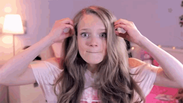 a girl with long blonde hair wearing a pink shirt with a horse on it
