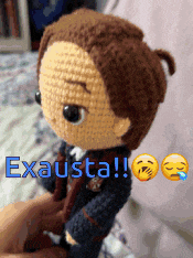 a person is holding a crocheted doll that says exausta on it
