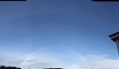 a rainbow is visible in the sky above a building