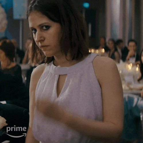 a woman in a purple top is standing in front of a crowd and the word prime is on the bottom right