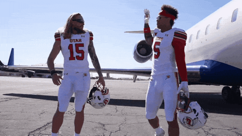 two utah football players are standing next to each other