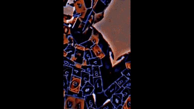 a man is covered in playing cards including a stack of cards with the number 6 on it