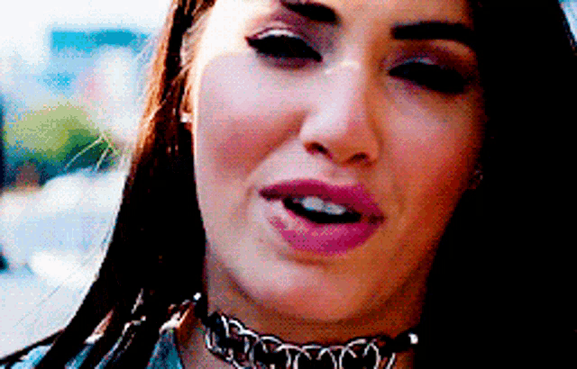 a close up of a woman wearing a choker and pink lipstick