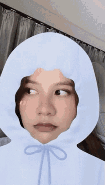 a girl wearing a white hoodie with a blue bow