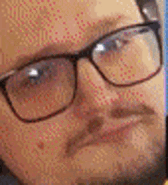 a close up of a man wearing glasses and a beard making a funny face .