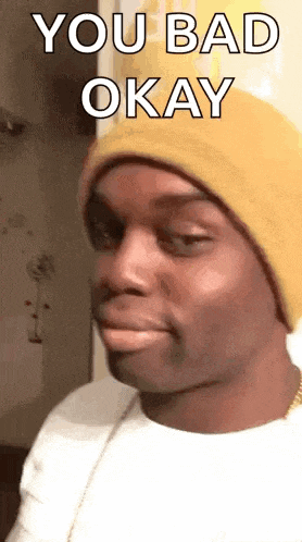 a man wearing a yellow beanie is making a funny face .