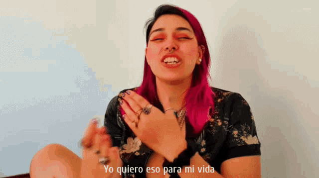a woman with pink hair has the words yo quiero eso para mi vida above her