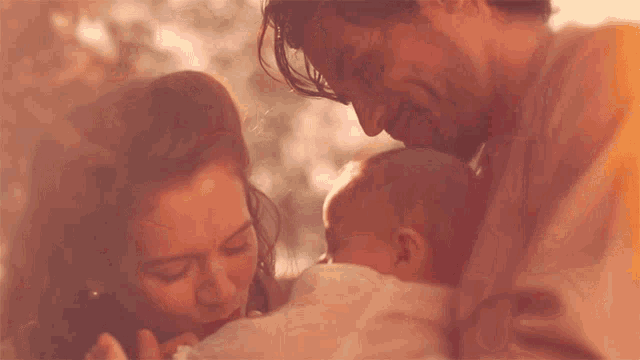 a man and woman are holding a baby in their arms