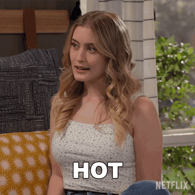 a woman is sitting on a couch with the word hot written on her chest