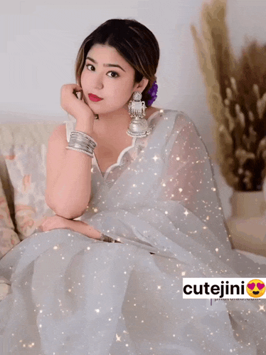 a woman wearing a white saree with cutejini on the bottom right
