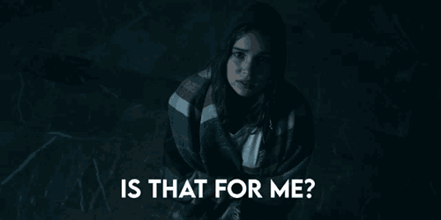 a woman is wrapped in a plaid blanket and asking is that for me