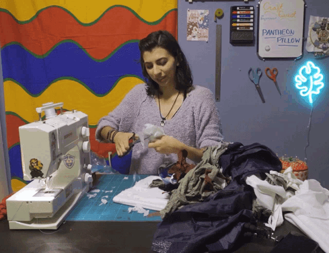 a woman is working on a pantheon pillow in front of a white board