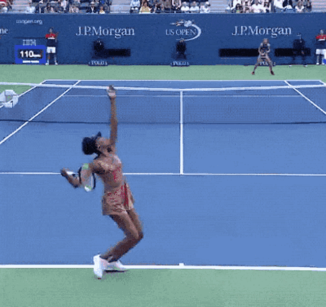 a woman in a bikini is serving a tennis ball in front of a j.p. morgan banner