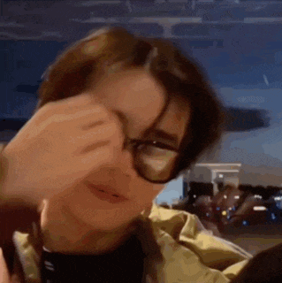 a close up of a person wearing glasses and a jacket .