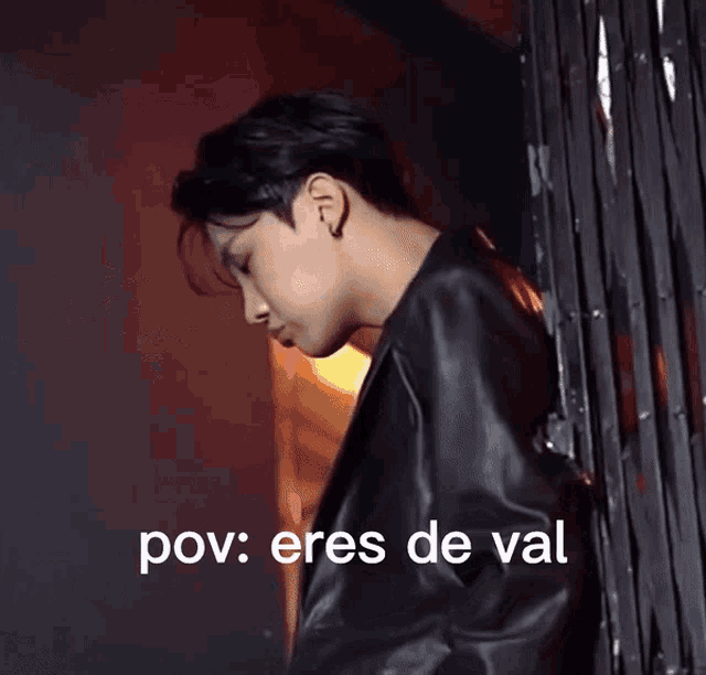 a man in a black jacket is standing next to a fence with the words pov : eres de val below him