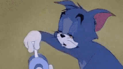 tom from tom and jerry is holding a stick in his hand and making a hole in the wall .