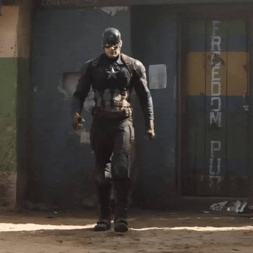 a man in a captain america costume stands in front of a sign that says freedom