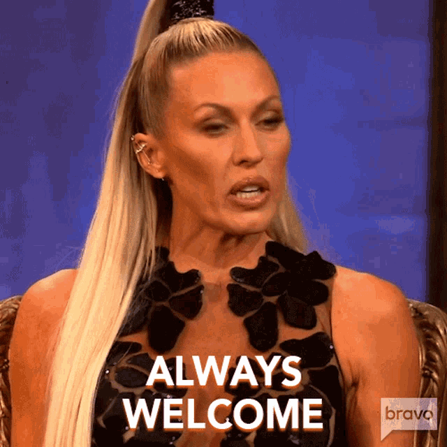 a woman in a black dress is sitting in a chair and says always welcome