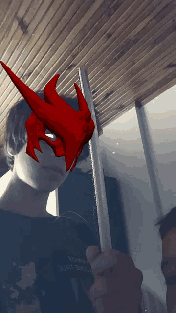 a man wearing a red mask holds a sword