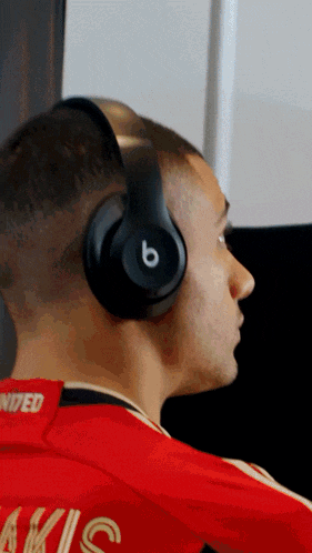 a man wearing beats headphones and a red shirt with the number 9 on the back