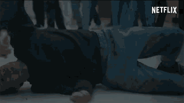 a man is laying on his back on the floor in front of a crowd of people .