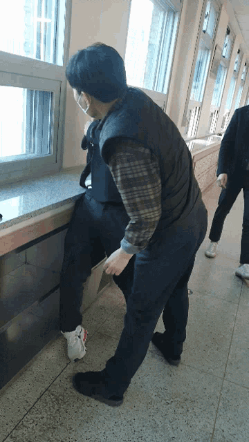 a man wearing a mask is helping another man