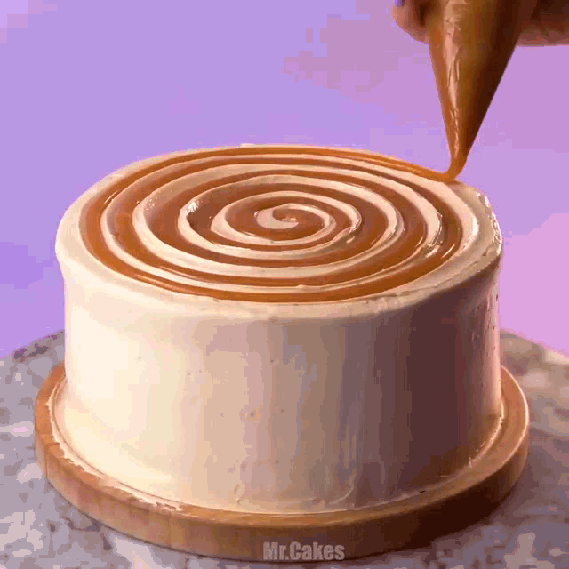 a cake with a swirl of caramel icing is being decorated by mr. cakes