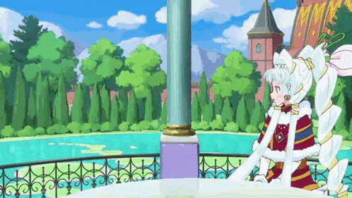 a girl in a white dress is sitting on a balcony overlooking a lake .