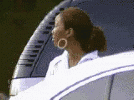 a woman with hoop earrings is sitting in a white car .