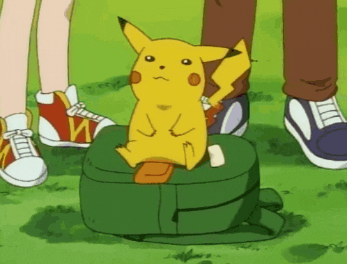 a pikachu sits on top of a green bag