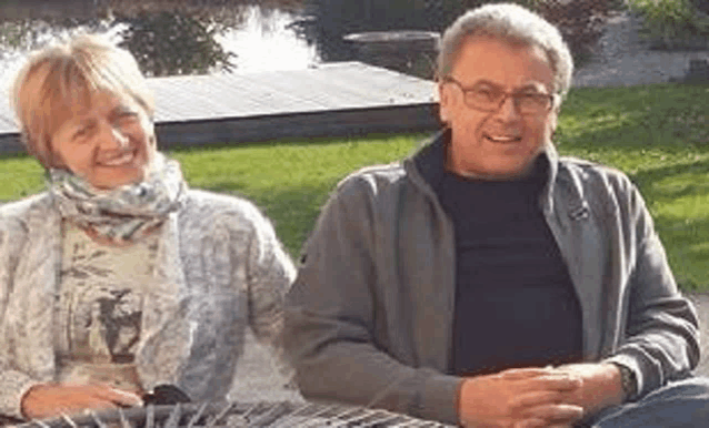 a man and a woman are sitting next to each other on a bench in a park .