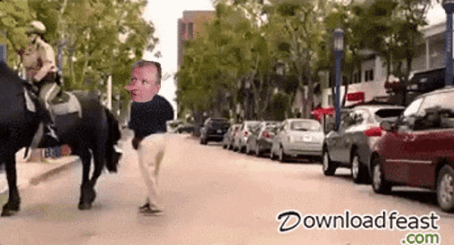 a man on a horse is walking down a street with a download feast.com logo in the corner