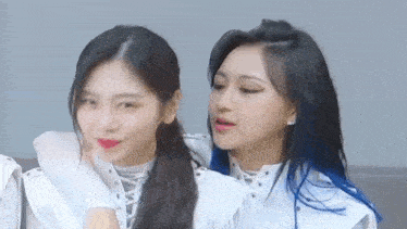 two women are standing next to each other and looking at each other .