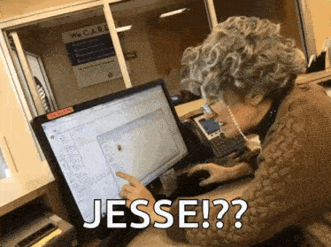 a woman sitting at a desk looking at a computer screen with the words jesse on the bottom